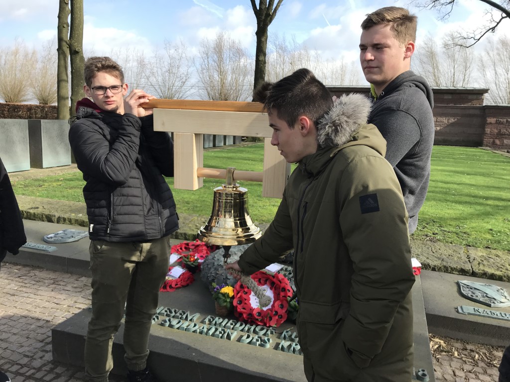 Luis Ermert und Lukas Reihs tragen die Glocke. Leon Hein läutet zum Gedenken in Langemark (Belgien) (Mittel)